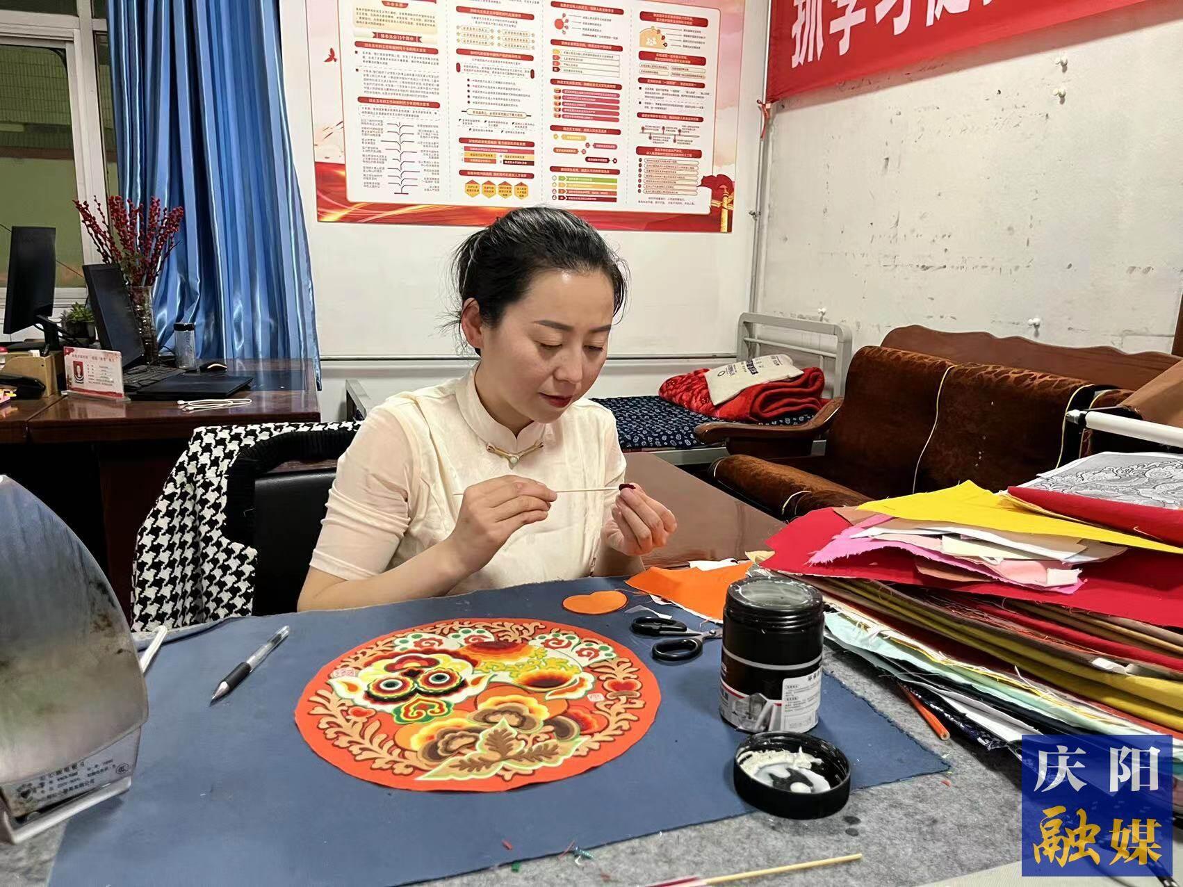 李慶英正在創(chuàng)作布貼畫作品。